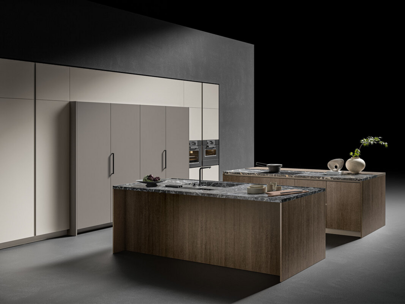 Basi isola CX 13 essenza rovere castoro. Top pietra naturale grigio Carnico. Colonne CX 13 laccato opaco grigio seta. Colonna folding laccato opaco grigio aston. Basi CX 11 acciaio inox mat.